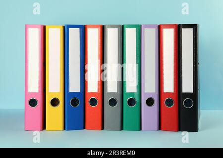 Many hardcover office folders on light blue background Stock Photo
