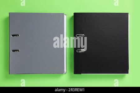 Office folders on light green background, flat lay Stock Photo