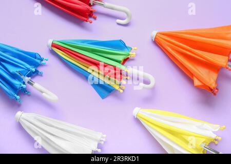 Many different umbrellas on lilac background Stock Photo