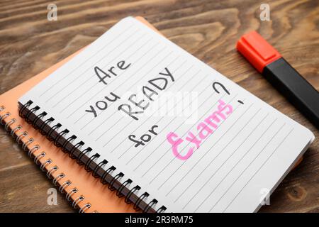 Notebooks with question ARE YOU READY FOR EXAM? and marker on brown wooden background Stock Photo