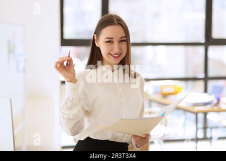 Young woman smiles holding investigation papers and pen Stock Photo