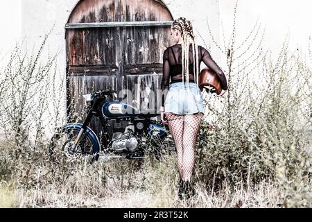 girl and Royal Enfield 500 motorbike, balearic islands. Stock Photo