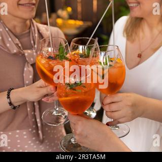 Happy friends spending time together, drinking Aperol spritz cocktail Stock Photo