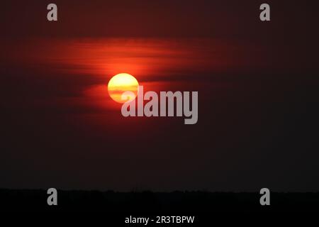 Romantic sunset, dramatic background, red sun with spots. Stock Photo
