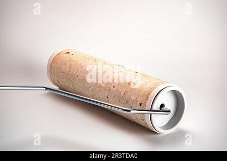 View of dirty used sticky remover roller with different kinds of particles, dust and animals hair on sticky paper isolated on white background. Stock Photo