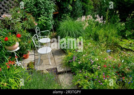 Seat in the garden with white chairs Stock Photo