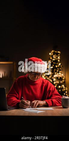 Portrait of old Santa Claus answering Christmas letters in his home office Stock Photo