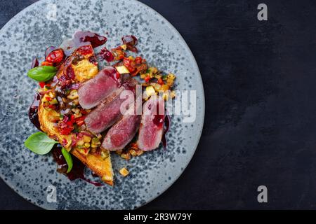 Traditional roasted Italian panettone tagliata di manzo with sliced beef steak and vegetable served as top view on a Nordic desi Stock Photo