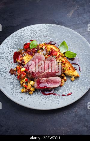 Traditional roasted Italian panettone tagliata di manzo with sliced beef steak and vegetable served as close-up in a Nordic desi Stock Photo