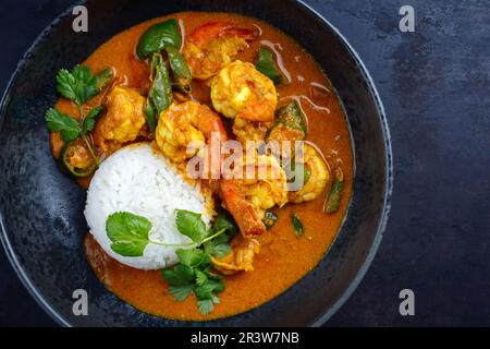 Traditional Thai kaeng phet red curry with chili and basmati rice served as top view in a Nordic design bowl Stock Photo