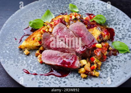 Traditional roasted Italian panettone tagliata di manzo with sliced beef steak and vegetable served as close-up in a Nordic desi Stock Photo