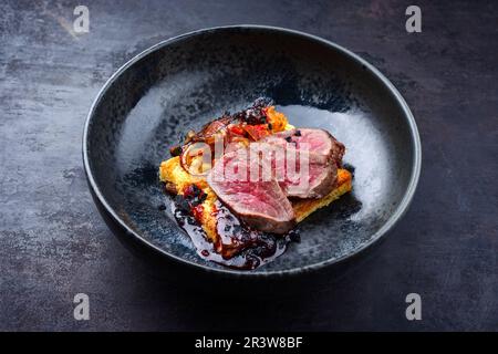 Traditional roasted Italian panettone tagliata di manzo with sliced beef steak and vegetable served as close-up on a Nordic desi Stock Photo