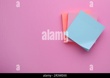 Paper notes on pale pink background, top view. Space for text Stock Photo
