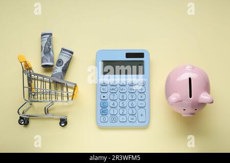Flat lay composition with piggy bank and calculator on beige background Stock Photo