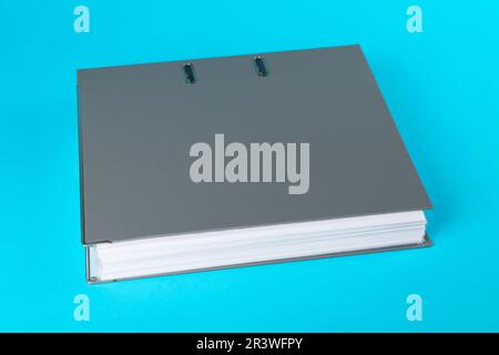 Grey hardcover office folder on light blue background Stock Photo