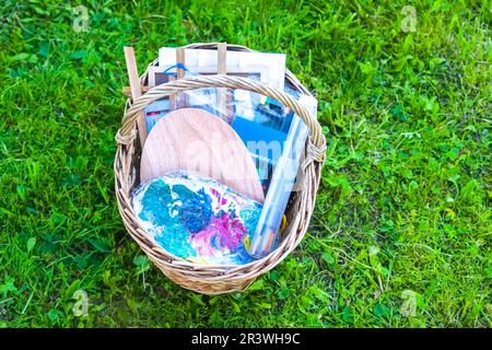 Painting brushes and acrylic paints. Creative tools in the basket on green grass background. Stock Photo