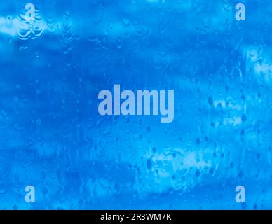 The blue of the sea with water drops on the pane Stock Photo