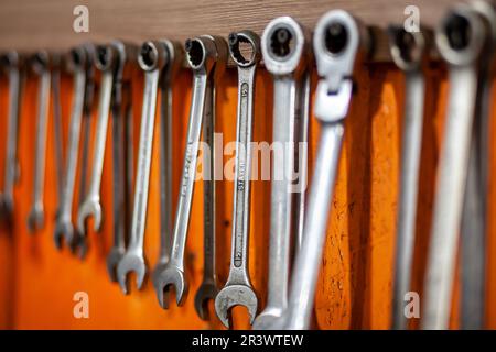 05.17.2023, Kemerovo, Moscow. Keys and work tools hang on the wall in a car repair shop or garage. Dirty, working tool of an auto mechanic Stock Photo