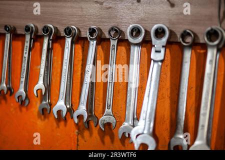 05.17.2023, Kemerovo, Moscow. Keys and work tools hang on the wall in a car repair shop or garage. Dirty, working tool of an auto mechanic Stock Photo