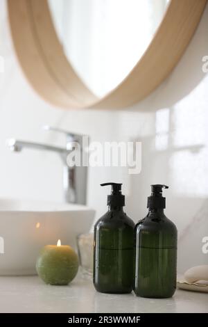 Green soap dispensers on countertop near sink in bathroom Stock Photo