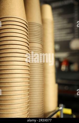 Stacks of takeaway paper coffee cups in cafe, closeup Stock Photo