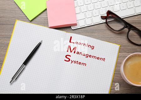 Notebook with text Learning Management System on wooden table, flat lay Stock Photo
