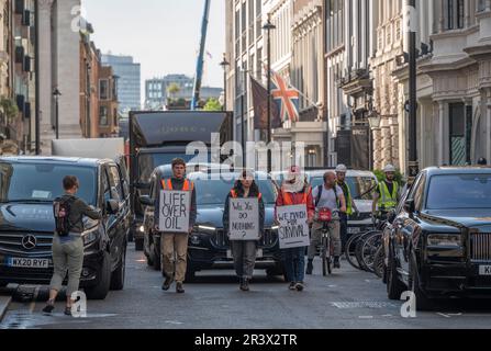 Dover Street, Mayfair, London, UK. 25th May, 2023. Three just stop oil protesters bring morning rush-hour traffic to a crawl with a go slow walk through Mayfair streets. Credit: Malcolm Park/Alamy Live News Stock Photo