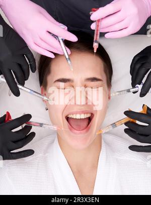 Conceptual beauty and cosmetology image of hands of several doctors holding syringes. Beauty and Cosmetology concept. Cosmetic p Stock Photo