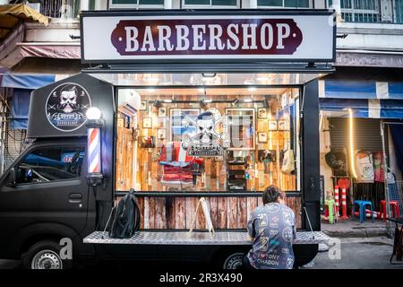 A mobile barber shop set up in Soi 1 Patpong Bangkok Thailand. Stock Photo