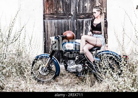 girl and Royal Enfield 500 motorbike, balearic islands. Stock Photo