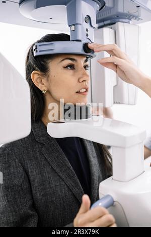 Young woman sitting at an x-ray machine in a dentist's office. Stock Photo