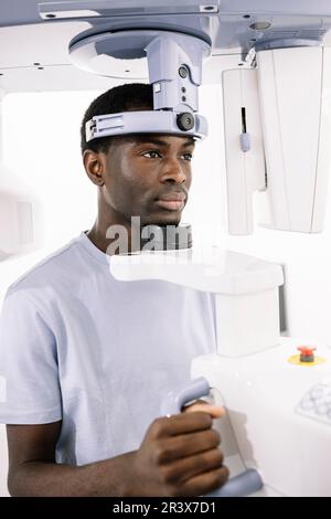 Portrait of African-American man sitting at an x-ray machine in a dentist's office  Stock Photo