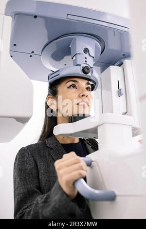 Woman sitting at an x-ray machine in a dentist's office. Stock Photo