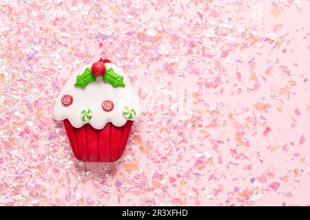 Vintage Plasticine clay cupcake on pink glitter background. Minimal Christmas concept. Happy New Year. Flat lay, top view, copy Stock Photo