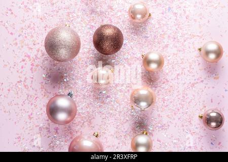 Elegant christmas tree balls on pink background decorated with tinsel. top view Stock Photo