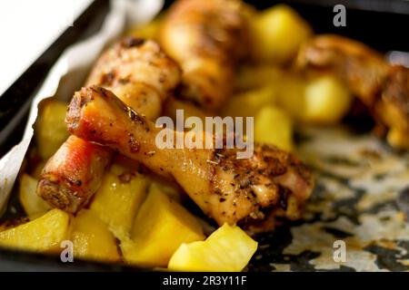 Chicken and potato. Defocus roasted chicken leg with potatoes cumin and garlic. Roasted chicken in sauce with potatoes. Close up. Copy space. Out of Stock Photo