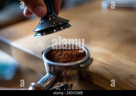Coffee prep, the home Barista making Espresso using a Grinding Machine Coffee extraction and using the hopper, closer detail shots Stock Photo