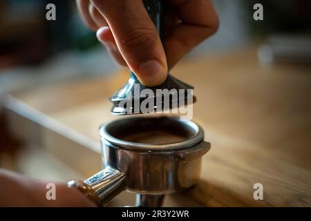 Coffee prep, the home Barista making Espresso using a Grinding Machine Coffee extraction and using the hopper, closer detail shots Stock Photo