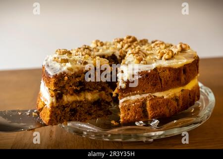 A delicious Carrot and Walnut Cake being cut, home-made baker. Stock Photo