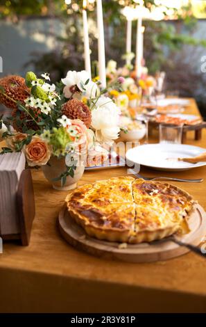 Wedding table for guests, decorated with candles, are served with cutlery and crockery and covered with yellow tablecloth Stock Photo