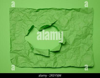 Texture of crumpled green paper with torn hole and green background, template for designer Stock Photo
