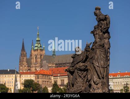 PRAGUE, CZECH REPUBLIC, EUROPE - Prague skyline with statue on Charles Bridge and St. Vitus Cathedral in distance. Stock Photo