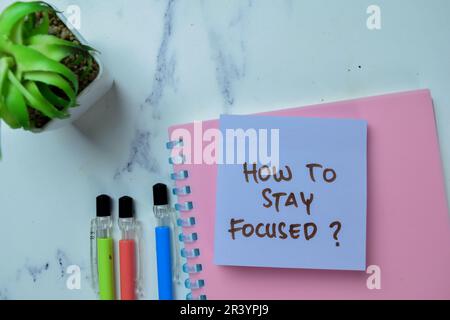 Concept of How To Stay Focused? write on sticky notes isolated on Wooden Table. Stock Photo
