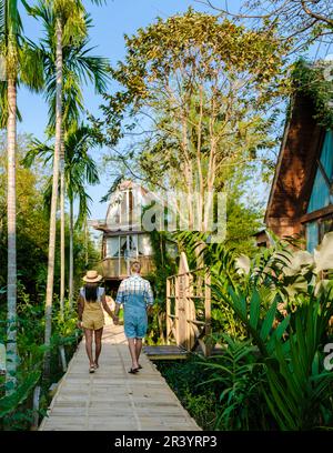 Wooden cottage surrounded by palm trees and a vegetable garden in the countryside. cabin rainforest Stock Photo