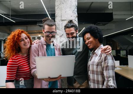 Diverse group of professionals meeting in office. IT programmers use computer, talk strategy Stock Photo