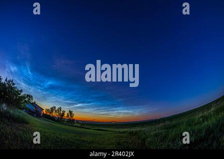 Noctilucent clouds illuminated by the red light of the setting Sun, Albert, Canada. Stock Photo