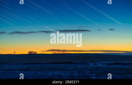 Star trails with the main trails at center of Jupiter (brightest) and below it Saturn, in the twilight sky. Stock Photo