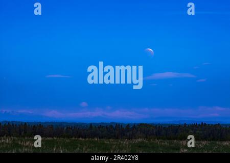 The total lunar eclipse of May 26, 2021, with a thin arc of the full moon visible at top. Stock Photo