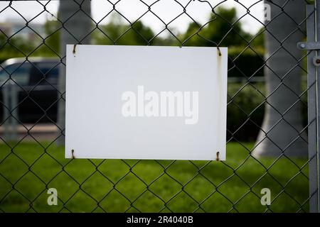 Blank white unlabeled sign with text space on a fence Stock Photo