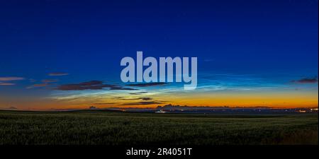 Wide angle view of noctilucent clouds over prairie field in Alberta, Canada. Stock Photo